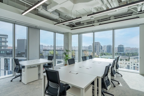 Interior de oficinas flexibles Utopicus Madnum con gran mesa y vistas panorámicas de Madrid